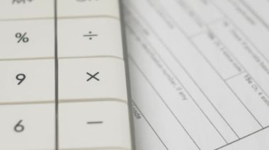 Hesap makinesi kullanarak belgelerdeki masrafları ve gelirleri hesapla. Finansal plan ve para yönetimi. Hesap makinesi tuşları, evraklarla birlikte masada döner. İş muhasebe işi konsepti