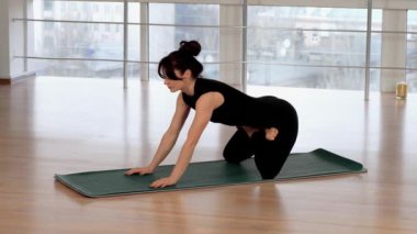 Spor zinde bir kadın evde yoga yapıyor, pilates egzersizleri yapıyor, stüdyodaki spor salonunda çıplak ayaklı Asyalı bir kadın. Spor salonunda spor paspası, sağlık hizmeti ve zihinsel terapi konsepti