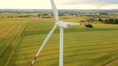 Yel değirmeni türbini yeşil tarım alanının hava sahasında temiz yenilenebilir enerji üretiyor. Elektrik, ekolojik tasarruf ve alternatif güç kaynağı