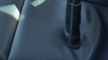 Otomobil yıkamacıdaki elektrikli sandalyeyi kapatıyorlar. Kadın araba yıkama makinesinde toz ve enkaz topluyor.