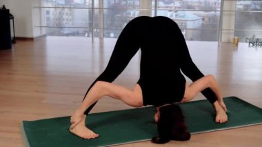 Genç bayan öğretmen sağlıklı vücut ve meditasyon için yoga akış asanas pratik ve fitness stüdyosu. Çıplak ayaklı kadın zihinsel sağlık ve rahatlama için esneklik egzersizleri yapıyor. Spor eğitmeni