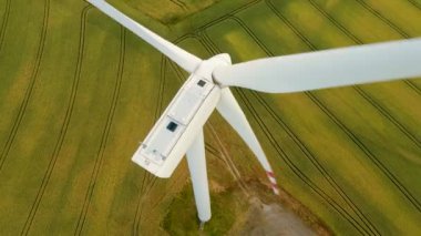 Yel değirmeni türbinleri buğday tarlasında yenilenebilir enerji üretir. Yakın çekim, üst görüş. Elektrik, ekolojik tasarruf ve alternatif güç kaynağı