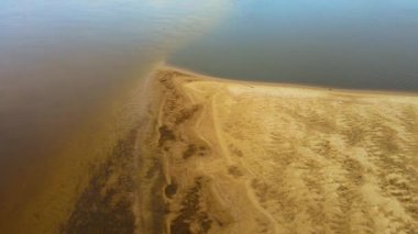 Hava görüntüsü Sandy 'nin iki ayrı su kütlesi tükürdüğünü gösteriyor. Tükürük erozyondan oluşan kumla kaplanmış. İklim değişikliği, nehirlerin kuruması, küresel ısınma