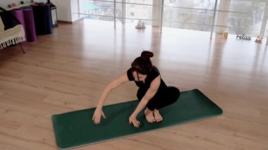 Fitness stüdyosunda çıplak ayakla yoga minderine uzanan Asyalı bir kadın. Ashtavakrasana pozu veren bir kadın. Spor salonunda spor yapan sağlıklı, kendine güvenen bir bayan.