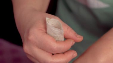 Eller jüt çuvalına kurumuş şifalı bitkiler döküyor. Çiçeklerdeki kuru aromatik yapraklar phyto fıçısında işlem için. Vücut bakımı için tıbbi bitkiler ya da spa 'da alternatif tıp. Phyto şişesi.