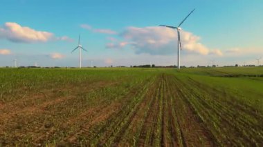 Rüzgar jeneratörü yenilenebilir elektrik üretir. Tarım manzarası arasında dönen yel değirmeni. Sürdürülebilir üretim: zararlı emisyonların azaltılması
