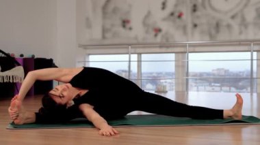 Pilates yoga pozisyonu, atölyede egzersiz ve antrenman yapan sağlıklı bir kadın. Çıplak ayaklı kadın zihinsel sağlık ve rahatlama için esneklik egzersizleri yapıyor. Yoga yapan kadın doğal denge.