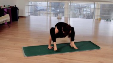 Yoga pozisyonunda duran zayıf kadın dengeyi sağlıyor, fitness stüdyosunda meditasyon yapıyor. Çıplak ayaklı kadın zihinsel sağlık ve rahatlama için esneklik egzersizleri yapıyor. Kendine güvenen sağlıklı bir kadın.