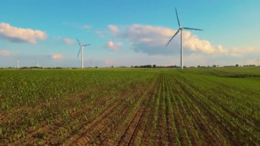 Rüzgardan gelen elektrik: Rüzgar jeneratörü çalışması. Kırsal tarım arazilerinde rüzgar türbini hareket ediyor. Doğanın bakımı: sanayideki toksik emisyonların azaltılması
