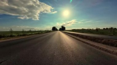 Gün batımında gökyüzü olan asfalt yol, karayolu ile seyahat. POV arabasının ön camından inanılmaz manzaralar, aktif yaşam tarzı, seyahat, rahatlama