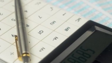 Ofisteki masasında kalem ve hesap makinesi olan belgeler, kapatın. Finans ve muhasebe, yatırımların geri dönüşü, şirket bütçe planlaması. Faturalar, vergiler, banka hesapları ve