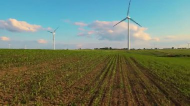 Rüzgar türbini temiz elektrik enerjisi üretir. Tarımsal alanda dönen yel değirmeni bıçakları. Endüstriyel atıkları azaltmak için yenilikçi yaklaşımlar