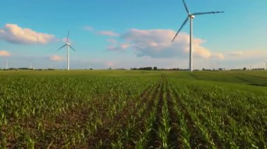 Elektrik jeneratörüyle yenilenebilir rüzgar enerjisi. Manzaralı çiftlik ortamında dönen yel değirmeni