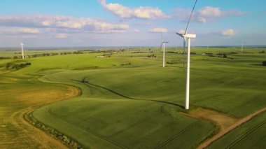 Rüzgâr enerjisi üretiminde temiz elektrik. Kırsal tarım arazisinde hareket eden rüzgar türbini. Çevre temizliği teknolojileri: toksik emisyonların azaltılması