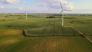 Yenilenebilir enerji: rüzgar jeneratörü elektrik üretir. Kırsal alanda rüzgar türbinleri zarifçe dönüyor. Gezegenimizin sağlığı için zehirli emisyonların azaltılması