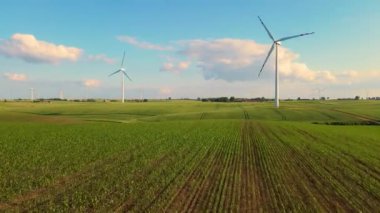 Rüzgar enerjisi jeneratörle elektriğe dönüştü. Kırsal alanda dönen yel değirmeni bıçakları. Endüstriyel atık azaltma yoluyla doğayı korumak