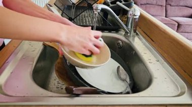 Modern Mutfakta Bulaşık Süngerle Lavabo ve Sabunlu Su Öğleden Sonra Işığında. Bulaşıkçı kişi eksiksiz temizliğin öneminin altını çiziyor. Sorumluluk, ev işi ve temizlik.