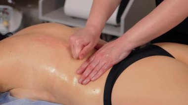 Güzellik salonundaki dinlendirici ya da canlandırıcı prosedür sırasında dişiye elle masaj yapan el terapisti ellerini kapat. Elle canlandırma sırasında klinikteki koltukta uzanan rahat kadın.