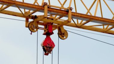 Mavi gökyüzüne karşı hareket halindeki vinçler, yaklaşın. Ev yenileme konsepti. İnşaat vinci yük taşıyor