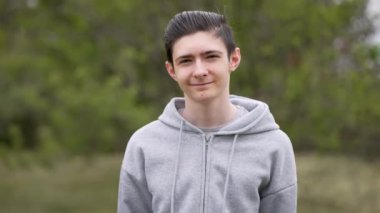 Açık havada gülümseyen genç çocuk portresi. Temiz havadan hoşlanan mutlu ergen çocuk, portre çekimi. Açık havada gülümseyen neşeli genç çocuk.