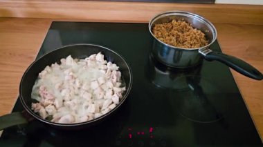 Cozy Kitchen Setting 'deki ocakta kızarmış tavuk ve lapa pişiriyorum. Modern mutfakta indüksiyon sobası paneli