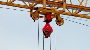 Modern gökdelenleri endüstriyel ekipmanlarla inşa etme sürecini kapatın. Mavi gökyüzüne karşı hareket halindeki vinçler, yaklaşın.