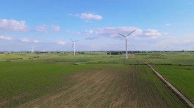 Rüzgar jeneratörü temiz elektrik enerjisi üretir. Rüzgar türbini geniş tarım alanının ortasında dönüyor. Ekolojideki yenilikler: zehirli endüstriyel atıkların azaltılması