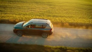 Araba toprak yolda hız yapıyor, kendine güvenen bir kadın sürüş yapıyor, arkasında toz bulutu bırakıyor. Kadın sürücü kontrol ve kararlılık gösterirken SUV hızla yeşil alanlarda ilerliyor. Otomatik seyir devam ediyor