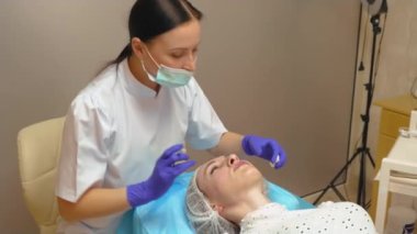 Profesyonel güzellik doktoru genç ve güzel bir kadının dudaklarına hyaluronik dolgu yapar. Dudak büyütme prosedürünü uygula. Yüz bakımı için reklam kavramı