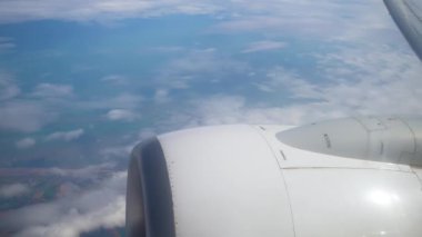 Gün Işığı Seyahati sırasında Uçak Pencereden Hava Görüntüsü Bulutları ve Manzaraları. Bulutları ve karasal manzarayı açık havada uçak kanadının altında karıştır