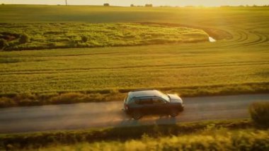 Sıcak güneş ışığı altında toprak yolda araba süren bir kadın. Toz bulutu altında. Toz yükseldikçe doğal güzelliği ve modern keşifleri harmanlayan arazi aracı kırsalda hareket ediyor. Otomatik