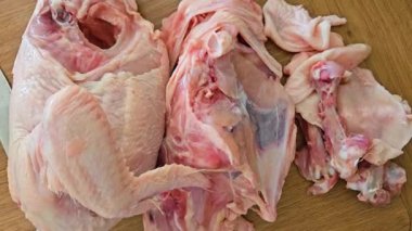 Güpegündüz yemek hazırlama sırasında Mutfak Masasında Ahşap Kesme Kurulunda kesilmiş tavuk leşi. Pişirmeden önce taze et doğramak. Yemek için kesilmiş kümes hayvanlarını yakın plan çek.