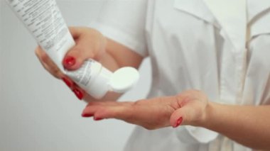 Spa terapisti başvuru için besin takviyeli krem dağıtıyor. Rahatlatıcı tedavi için dikkatlice cilt kremi hazırlıyorum. Spa terapisinin gençleştirilmesi için profesyonel ürün kullanımı