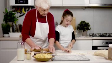 Güzel küçük kız mangırı yuvarlarken iyi iş çıkarıyor. Granny 'nin aşçılık dersleri olumlu gidiyor. Büyükanne ve torun sıcak mutfakta hamur hazırlıyorlar. Aile