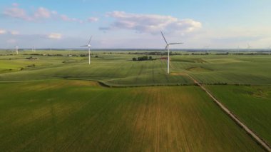 Rüzgar jeneratöründen çevre dostu enerji. Kırsal tarım zeminine karşı hareket eden yel değirmeni bıçakları. Koruma çözümleri: zehirli atıkların en aza indirgenmesi