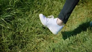 Tanımlanamayan bir kadın çimen tarlasında bacak esnetiyor, yayan esneklik ve denge üzerine odaklanıyor. Kadın, kesin hareketler ve kontrollü duruşla ısınma hareketleri sergiliyor. Bayan daha aşağılarda takılıyor.