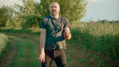 Kel erkek neşeli hareketler ve neşeli enerjiyle neşeyle dans ediyor. Kel kafalı adam ritmik hareket ediyor ve mutlu dans ediyor. Erkek, eğlenceli ve hareketli bir şekilde dans ediyor.