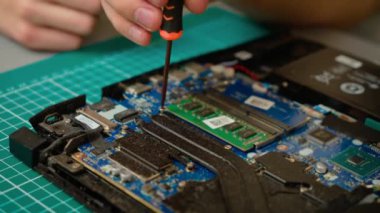 Oğlu, babasına bilgisayar soğutma sisteminde yardımcı olurken vidaları söküyor. Çocuk dizüstü bilgisayarı tamir etmek için tornavida kullanıyor, erkek akıl hocasıyla işbirliği yapıyor. Çocuk bilgisayar bakımı için vidaları kaldırıyor