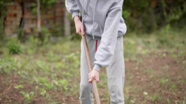 Bahçede bahçe aletleriyle çalışan çiftçi. Erkek çiftçi çeşitli bahçe aletleriyle bahçeyle ilgileniyor. İnsan yetiştiriciliği iş için bahçe malzemesi kullanıyor.