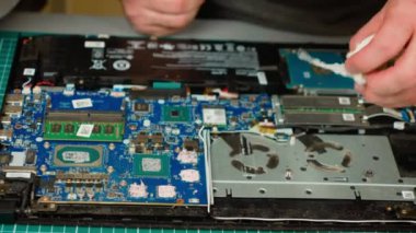 Oğlu tarafından tanınmayan bir baba dizüstü bilgisayarını temizliyor, termal macunu bileşenlerden temizliyor. İç donanım üzerinde çalışarak hassas parçaların bakımını sağlıyorlar. Takım onarımı