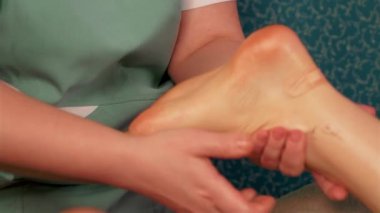 Bir kıza ayak masajı yaparken ellerini kapat. Spa masajında kadın için rahatlatıcı tedavi uygulanıyor.