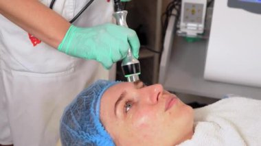 Güzellik kliniğinde kısmi kaldırma ve yüz boşaltımı. Donanım kozmetolojisi. Kapatın. Güzellik uzmanı yüz yenileme tedavisi yapıyor.