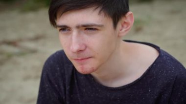 Çocuk dışarıda karpuz yiyor, yoğun bir ifadeyle tatlı ve sulu meyvelere odaklanıyor. Erkek, taze karpuz diliminin tadını çıkartıyor, konsantre bir şekilde ısırıyor. Adam karpuzun tadını çıkarıyor.