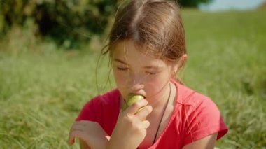 Armut yiyen, sulu meyveleri ısıran genç bir kız. Kadın taze armudun tadını çıkarıyor, doğal tatlılığın tadını çıkarıyor. Bayan olgun armudu tadıyor, güneşli ortamda taze tadını takdir ediyor.
