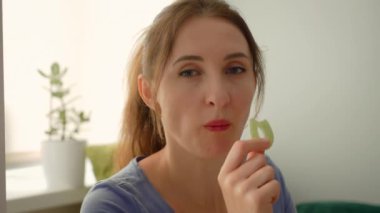 Jöleli şeker yiyen ve şekerlerin tadını çıkaran bir kadın. Kadın, parlak aromalı çiğnenmiş dokudan hoşlanıyor. Bayan lezzetli şekerleri takdir ediyor.