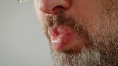 Adam çatalla hamur köftesi yiyor. Yakından yemek yerken erkek çiğneme anı. Hamur tatarken yemeğin tadını çıkaran adam