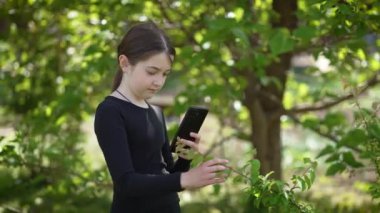 Nişanlı kız cep telefonu kamerasıyla ağaç dalının fotoğrafını çekiyor. Büyülenmiş çocuk, akıllı telefonunu kullanarak dalın görüntüsünü yakalıyor. Mobil kablosuz teknolojiler, yenilikler, kusursuz bağlantı