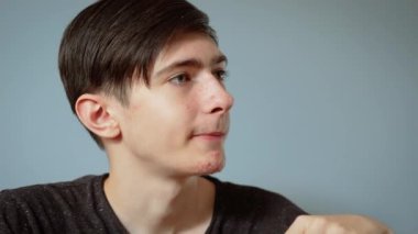 Yemekte peynir yiyen portre çocuğu. Erkek gençlik elinde peynir dilimi ve odaklanmış bir ifade ile. Gençler sakin ve rahat yemek anlarında basit atıştırmalıkların tadını çıkarıyorlar.