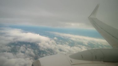 Cloudy Flight 'ın ortasındaki uçak penceresinden büyüleyici sonbahar gökyüzü görüntüsü. Uçaktan bulutlu görüntü ve kanatta jet