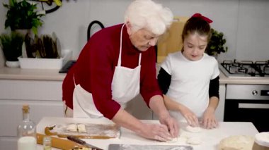 Büyükannem toruna hamurdan yemek yapmayı öğretiyor. Son sınıf öğrencisi ve mutfak masasındaki tortillalara raptiye takmış tatlı küçük kız hamuru. Doldurulmuş ev yapımı pastalar. Jenerasyon kadınları